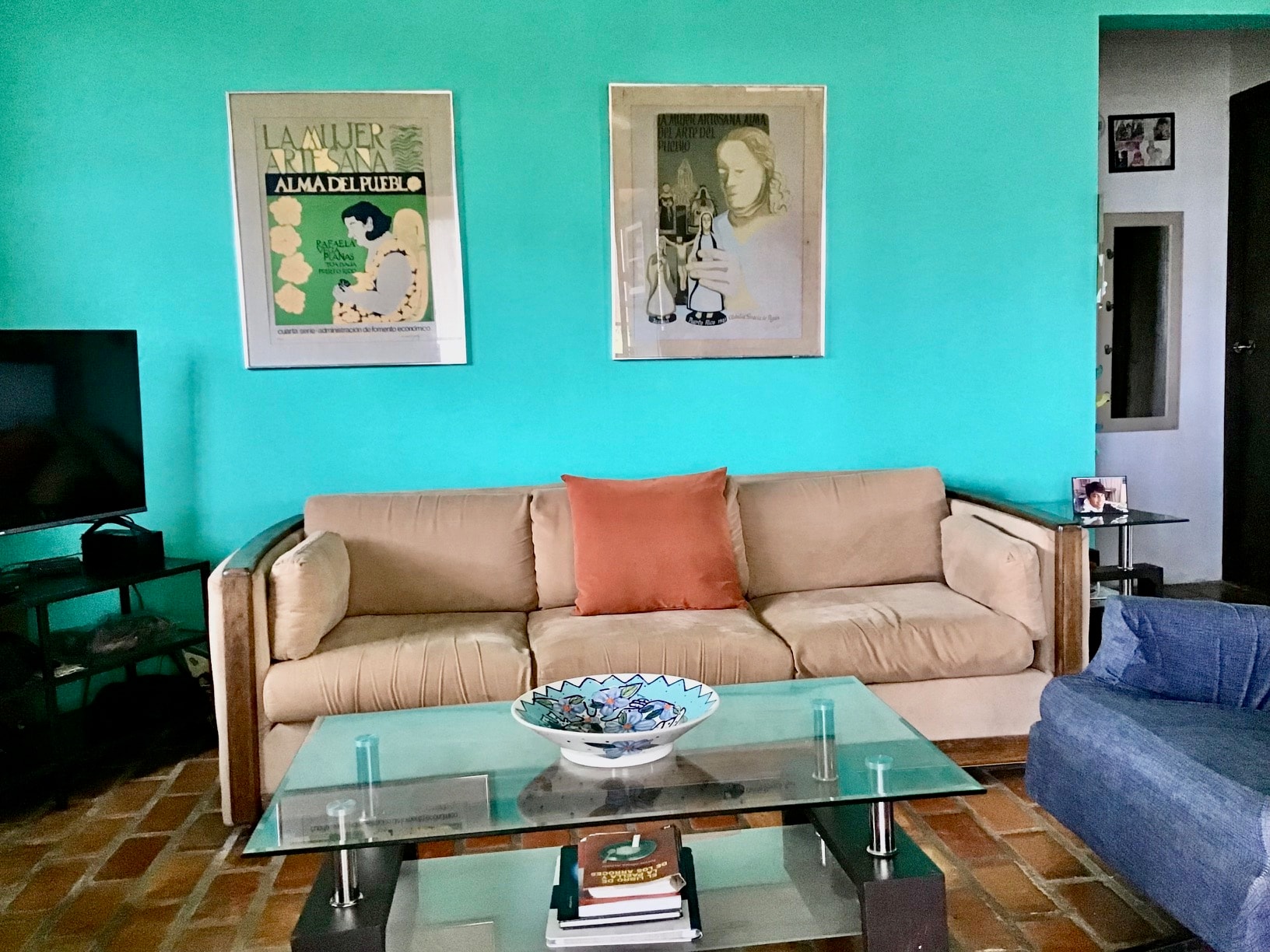 The Nest living room with turquoise walls and Puerto Rican art